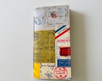 May include: A handmade journal with a collage of vintage ephemera. The cover features postage stamps, handwritten letters, and airmail labels in red, blue, and yellow. The journal is stitched together with yellow thread.