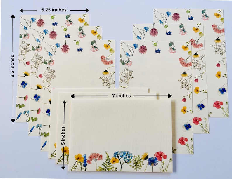 May include: Set of eight floral note cards with white envelopes. The cards are 5 inches by 7 inches and feature a pressed flower design with pink, yellow, blue, and green flowers. The cards are perfect for writing thank you notes, birthday cards, or any other occasion.