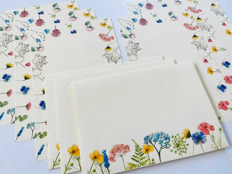 May include: Set of six blank stationery cards with floral designs. The cards feature watercolor illustrations of various flowers in shades of blue, pink, yellow, and green. The cards are perfect for writing letters, notes, or invitations.