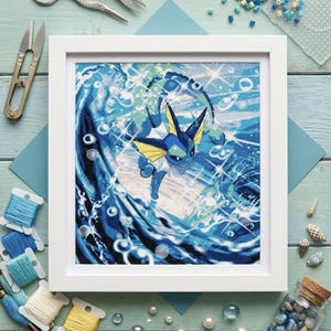 May include: A square framed cross-stitch embroidery featuring a blue and yellow aquatic creature with large ears and a white collar, centered amidst a dynamic, swirling ocean wave with sparkling light effects, bubbles, and deep blue water tones.