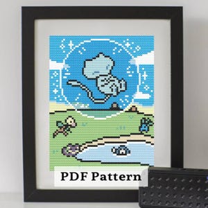 May include: Framed cross-stitch art featuring a light blue creature in a blue sky with a white outline. The scene includes green grass, a pond, and small plants. The text "PDF Pattern" is at the bottom.