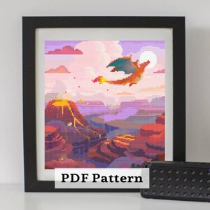 May include: Framed cross-stitch art featuring a pixelated dragon flying over a volcanic landscape. The artwork is in shades of orange, red, purple, and blue, with a full moon in the background. The text "PDF Pattern" is at the bottom.