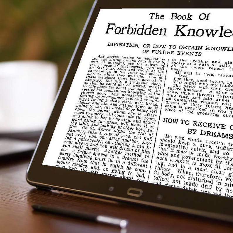 May include: A black tablet displays text from "The Book of Forbidden Knowledge." The text is in black font on a white background. The tablet is on a wooden surface.