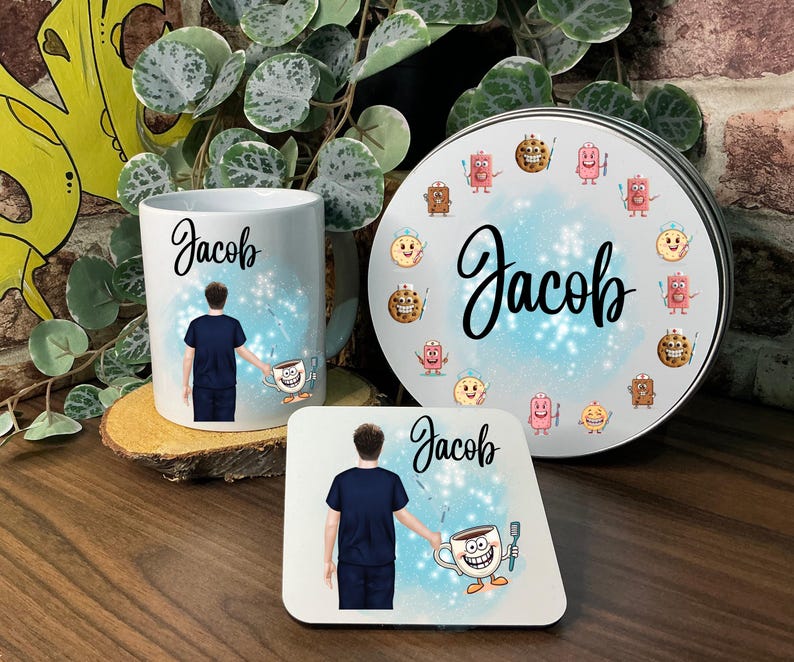 May include: A white ceramic mug, coaster, and round tin featuring the name "Jacob" in cursive. The mug and coaster have a graphic of a person in a blue uniform holding a coffee cup. The tin is decorated with cookie characters.