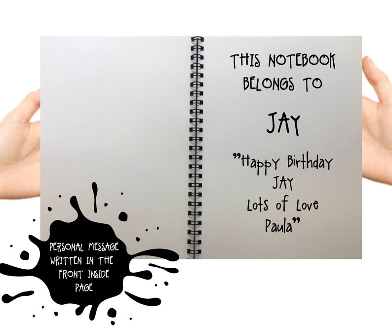 May include: A spiral-bound notebook with the text "THIS NOTEBOOK BELONGS TO JAY" and a birthday message. A black ink blotch with the text "PERSONAL MESSAGE WRITTEN IN THE FRONT INSIDE PAGE" is on the left.