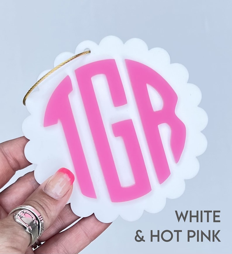 Peut inclure: Ornement rond blanc &agrave; festons avec un monogramme "TGR" rose vif au centre.  BLANC & ROSE VIF.