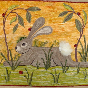 May include: A brown rabbit with a white tail sits in a field of green grass with red berries on branches above. The background is a yellow and orange sunset.