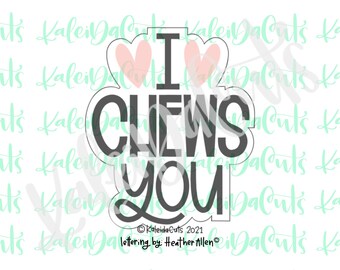 May include: A black and white cookie cutter with the text "I CHEWS YOU" and two pink hearts. The text is in a playful font.