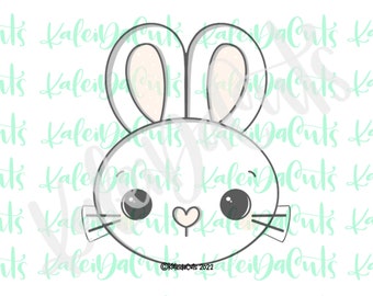 May include: A white bunny cookie cutter with a heart-shaped nose and large, round eyes. The cutter is outlined in gray and has a light gray background.