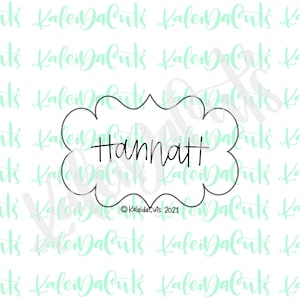 May include: A black and white cookie cutter in the shape of a cloud with the word "Hannatt" written inside. The cookie cutter is on a white background with a green pattern.