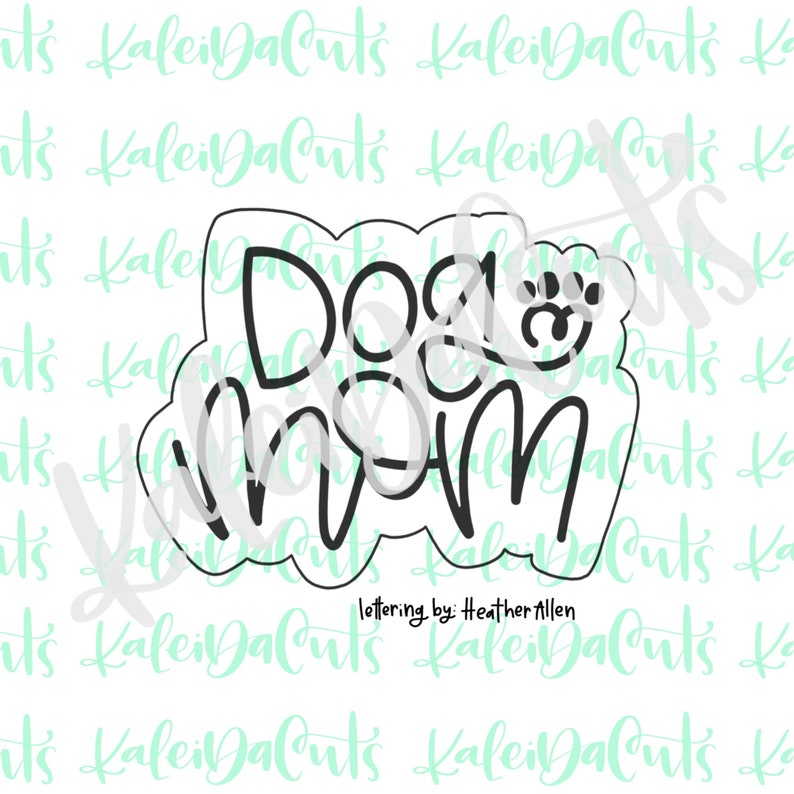 May include: A black and white cookie cutter in the shape of the words "Dog Mom" with a paw print next to the word "Dog".