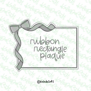May include: A gray ribbon tied in a bow with a gray rectangle plaque with the text "ribbon rectangle plaque" on it.