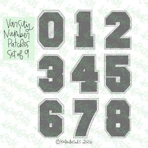 May include: A set of nine varsity number patches featuring the digits zero through eight. Each number is dark gray with a silver glitter border. The text "Varsity Number Patches Set of 9" is printed in black on a light green square background.