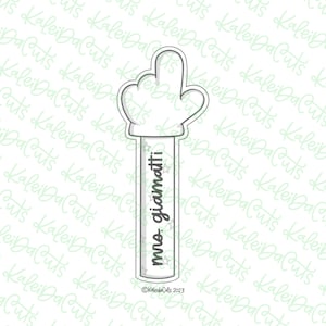 May include: A white cookie cutter in the shape of a hand with the text "mro. giamatti" on the handle. The cookie cutter is decorated with small stars.