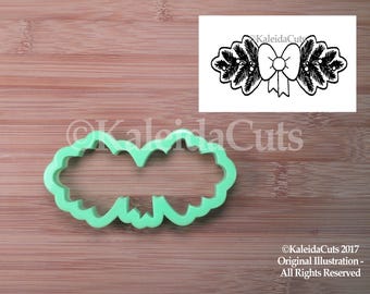 May include: Green plastic cookie cutter shaped like a Christmas wreath with a bow in the center.