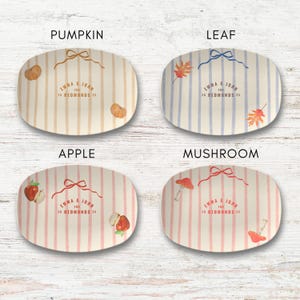 Puede incluir: Cuatro fuentes ovaladas con rayas verticales e ilustraciones tem&aacute;ticas. La fuente "Pumpkin" tiene calabazas, la fuente "Leaf" tiene hojas, la fuente "Apple" tiene manzanas y la fuente "Mushroom" tiene setas. Cada fuente tiene el texto "EMMA & JOHN THE 20 REDMONDS 25".