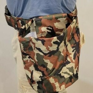 May include: A camouflage-patterned utility pouch with a zippered closure. The pouch is worn around the waist and has a large pocket on the front.
