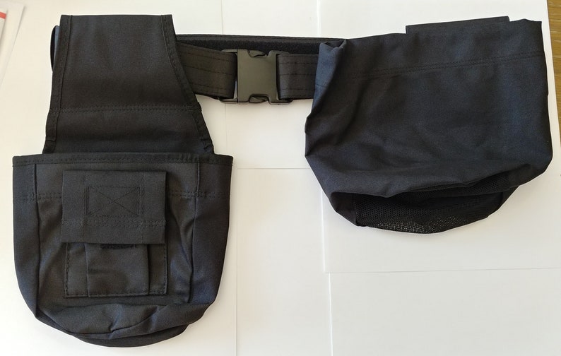May include: Black canvas tool belt with two pouches and a black adjustable buckle. The belt has a mesh pocket on the bottom of one of the pouches.