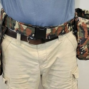May include: A camouflage-patterned utility belt with multiple pouches. The belt is made of a durable fabric and has a metal buckle. The pouches are also made of camouflage fabric and have drawstrings.