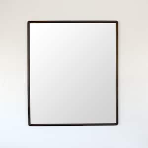 Puede incluir: Espejo rectangular con marco marrón oscuro. El espejo está montado en una pared blanca. El marco tiene un diseño fino y sencillo, y la superficie del espejo refleja el entorno.