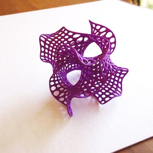 May include: A purple 3D printed object with a lattice design. The object is shaped like a flower with multiple petals.