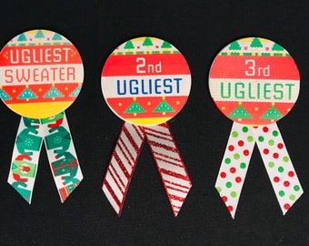 Può includere: Tre nastri colorati per il premio del concorso "Maglione più brutto". I nastri sono rotondi con testo e motivi festivi. Il primo nastro dice "Ugliest Sweater" e ha un nastro a fantasia verde e bianco. Il secondo dice "2nd Ugliest" con un nastro a righe rosse e bianche. Il terzo dice "3rd Ugliest" con un nastro a pois.