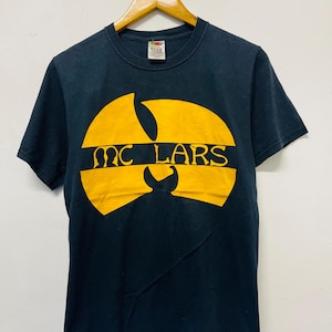 May include: A white ceramic mug with a black handle and the text "But First, Coffee" in a black, bold font. The mug is on a white surface. The mug appears to hold approximately 355 ml.