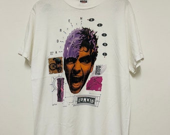May include: White t-shirt with a graphic print of a man's face with purple hair, a bicycle, and the word "Junkie".