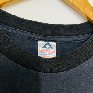 May include: A black t-shirt with a white tag that reads "Alstyle Apparel & Activewear 100% Cotton Pre-Shrunk Assembled in Mexico from US Fabric X-Large"