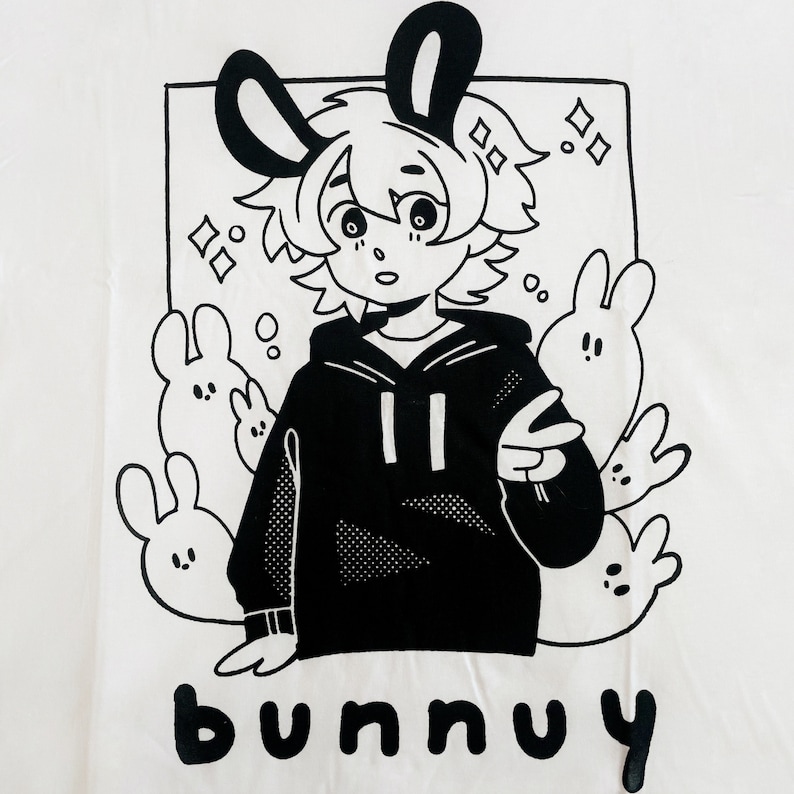 Puede incluir: Ilustraci&oacute;n en blanco y negro de un conejo de dibujos animados con una sudadera con capucha y rodeado de otros conejos. El texto "bunny" est&aacute; escrito debajo de la imagen.