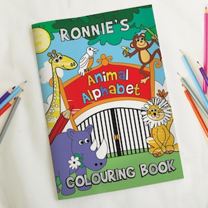 May include: A green, yellow, and red coloring book with the title "Ronnie's Animal Alphabet Coloring Book". The cover features a cartoon rhino, giraffe, monkey, lion, and bird.