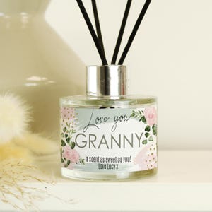 May include: A clear glass diffuser bottle with black reeds. The label says "Love you Granny" with floral and gold accents. The text "a scent as sweet as you! Love Lucy x" is also on the label. This is a home fragrance item.