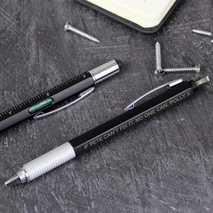 May include: Two black multi-tool pens with silver accents. One pen has a level and ruler, the other has a screwdriver. The pen with the screwdriver has the text "IF PETE CAN'T FIX IT, NO ONE CAN. POLLY X" engraved on it.