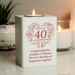 May include: A white candle holder with a lit tea light. The front displays a red floral heart design with "Happy 40 Anniversary" and a personalized message. A thoughtful gift for a 40th wedding anniversary.
