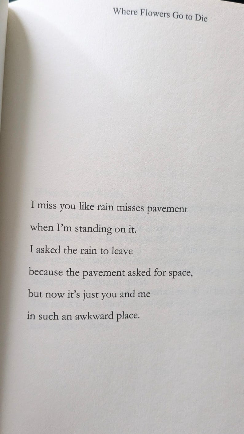 Może przedstawiać: Otwarta strona książki z tytułem "Where Flowers Go to Die". Na stronie znajduje się wiersz z wersami: "I miss you like rain misses pavement...in such an awkward place."