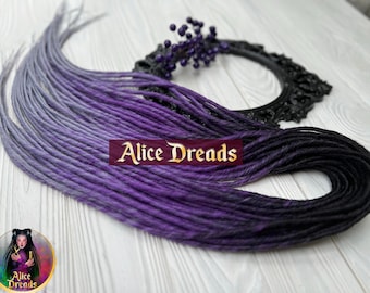 May include: A set of synthetic dreadlocks with a gradient color transition from light gray to purple and then to black. The dreadlocks are arranged in a fan shape on a wooden surface.