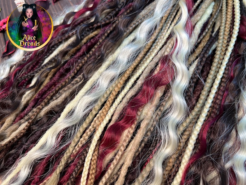 May include: A collection of synthetic dreadlocks in various shades of brown, blonde, and burgundy. The dreadlocks are wavy and have a natural, textured appearance.