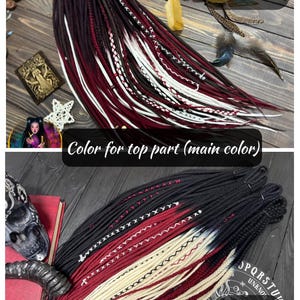 May include: A set of synthetic dreadlocks featuring two color variations. The top section displays a brown, burgundy, and white gradient with decorative wraps. The bottom section shows a black, burgundy, and cream gradient with cross-stitching.