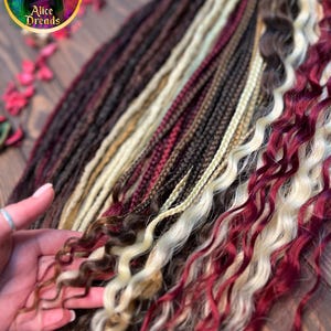 May include: A variety of synthetic hair extensions in different colors and textures, including straight, wavy, and curly. The colors include burgundy, blonde, and brown.