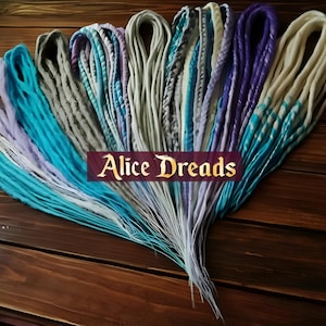 May include: A collection of colorful synthetic dreadlocks in shades of blue, purple, white, and gray. The dreadlocks are arranged in a fan shape and are tied together at the top.