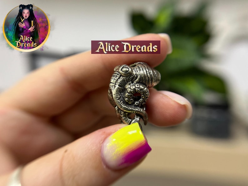 a person holding a tiny ring with a dragon on it