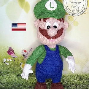 May include: A knitted doll featuring a character with a green hat displaying a white L, a brown mustache, a green long-sleeved shirt, blue overalls, and brown shoes. The doll has white gloves and a light skin tone. Text reads PDF Pattern Only.