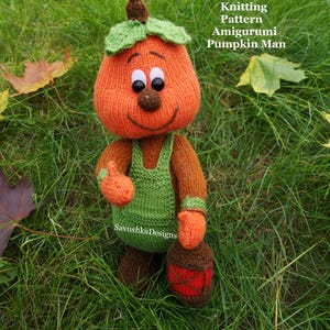 May include: A knitted amigurumi pumpkin character with a brown stem, green leaves, and a smiling face. It wears green overalls over brown arms and legs, holding a small red lantern. Text reads: PDF Halloween Knitting Pattern Amigurumi Pumpkin Man.