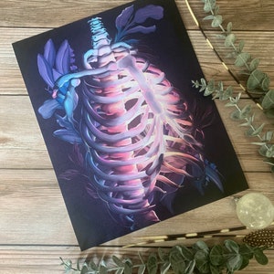 May include: A vibrant, abstract illustration of a human ribcage with glowing purple and blue hues. The ribcage is surrounded by stylized floral elements, creating a surreal and ethereal aesthetic.