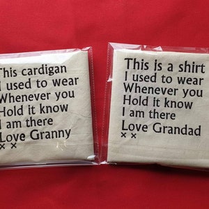 May include: Two white fabric squares with black text. The first square says "This cardigan I used to wear Whenever you Hold it know I am there Love Granny XX". The second square says "This is a shirt I used to wear Whenever you Hold it know I am there Love Grandad XX".