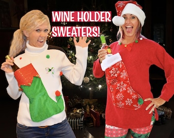 May include: Two people wearing festive Christmas sweaters with built-in wine bottle holders. The sweaters are red and white with a stocking design. The text "WINE HOLDER SWEATERS!" is displayed above the people.
