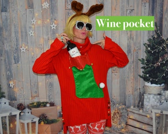 May include: Red Christmas sweater with a green stocking pocket on the front. The pocket has a white pom-pom and a bottle of wine is in the pocket. The sweater has reindeer and button details. The person wearing the sweater is wearing reindeer print leggings and has reindeer antlers on their head.
