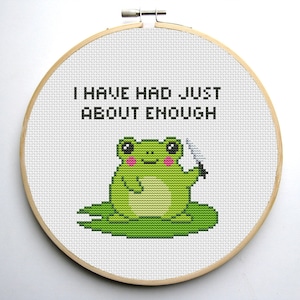 May include: Cross-stitch embroidery hoop featuring a green frog holding a knife and the text "I have had just about enough".