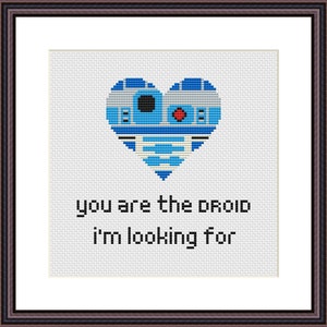May include: A white cross-stitch pattern with a blue and white heart-shaped R2-D2 droid and the text "you are the droid i'm looking for".