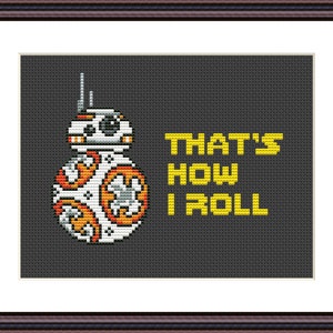 May include: A cross-stitch pattern featuring a white, orange, and gray robot with the text "That's how I roll" in yellow.